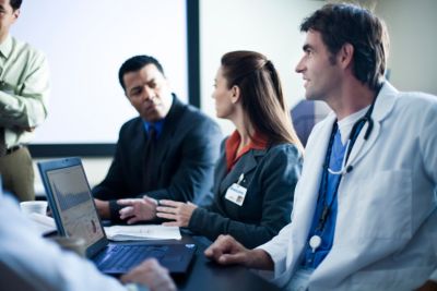 Healthcare professionals having a discussion in a conference room.