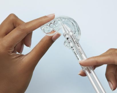 A closeup of a patient applying gel to a whitening tray