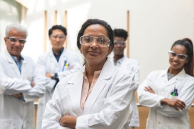 Clinicians in white coats standing together in a hospital corridor