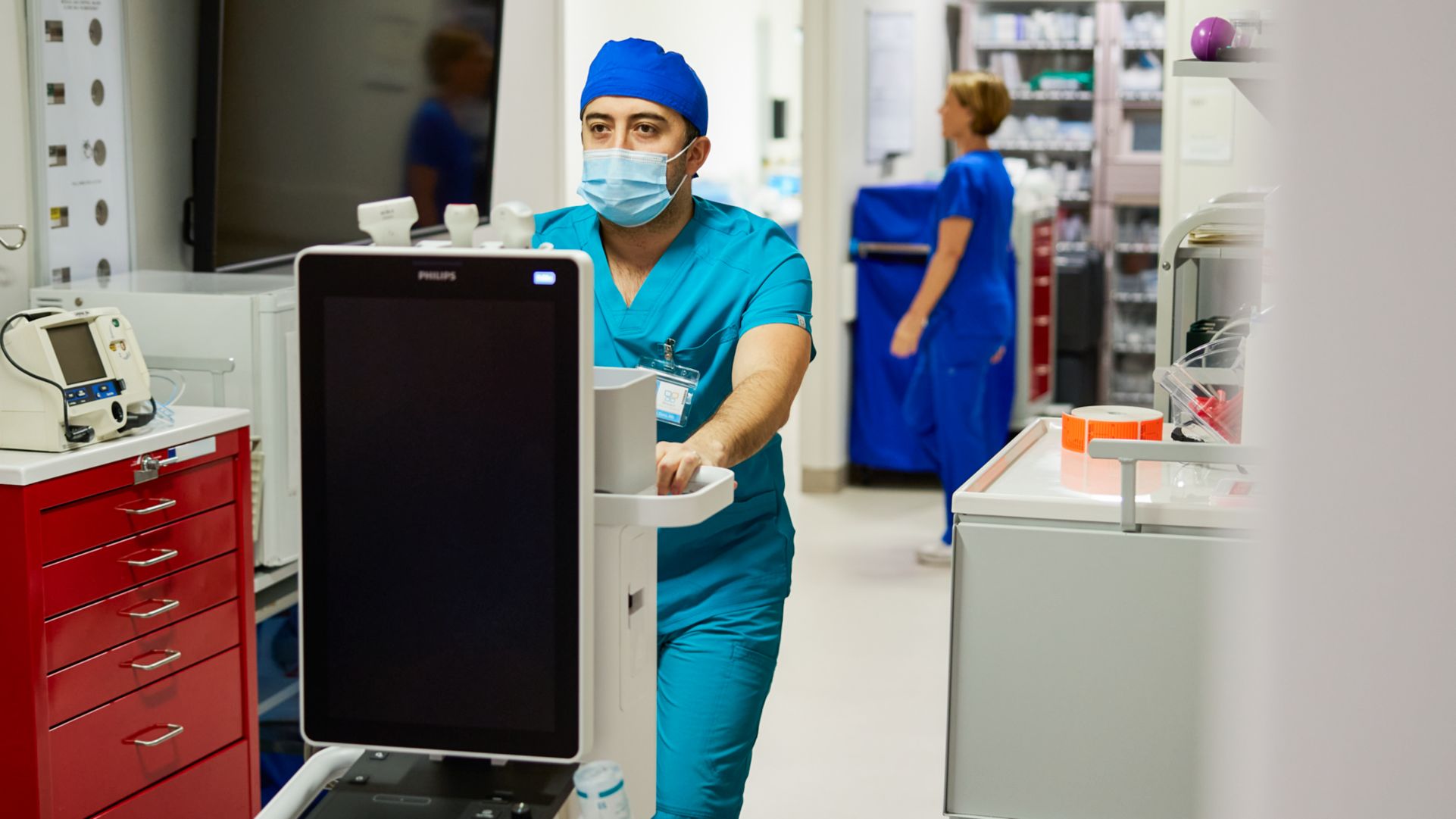 POC clinician wheeling Flash 5100 POC system down hospital hallway. 