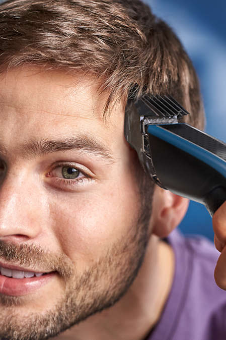 Mann trimmt sein Haar mit dem Haarschneider