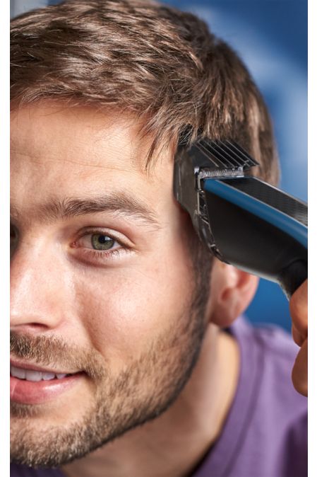 Mand trimmer sit hår med hårtrimmeren