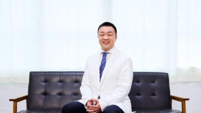 白衣を着て診療所に座る宮脇医師