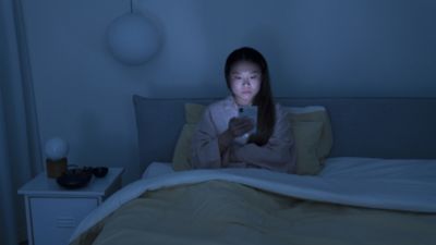 Woman Using Phone in Bed