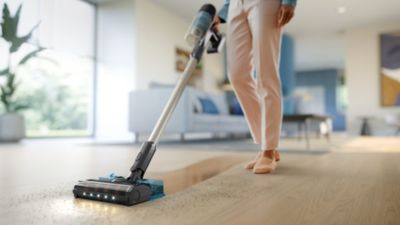 Cordless vacuum cleaner from the 2000 and 3000 series cleaning hard floor in a modern living room