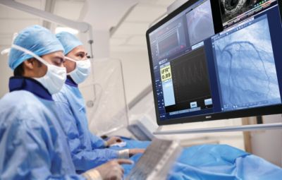 Profesionales de la salud revisando imágenes y mediciones iFR durante un procedimiento coronario