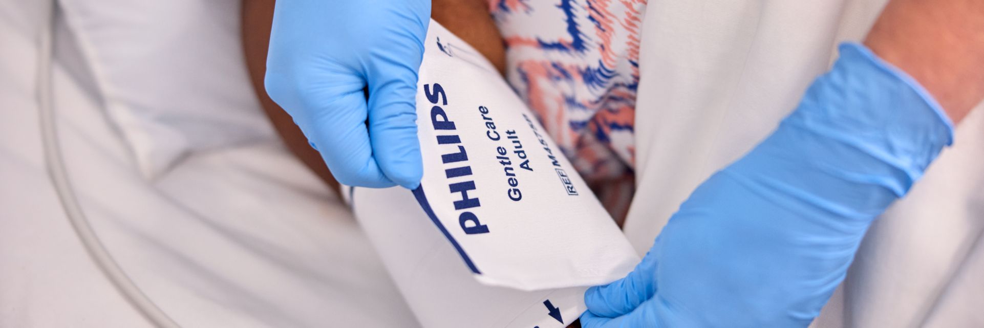 Image of a healthcare professional placing a blood pressure cuff on a patient's arm.