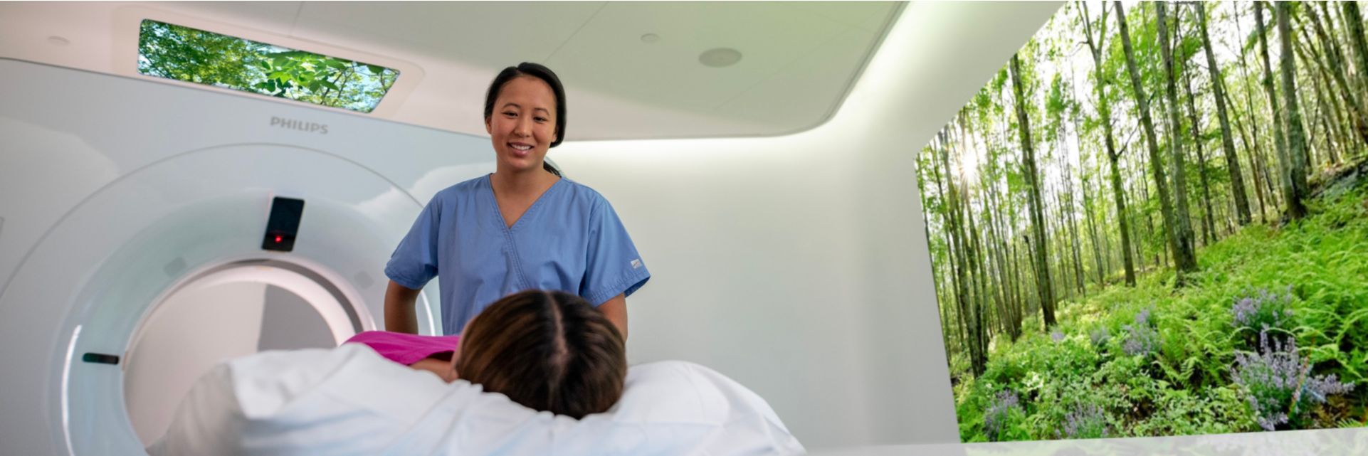 Technologist comforting patient before a CT exam in exam room with Ambient Experience. 
