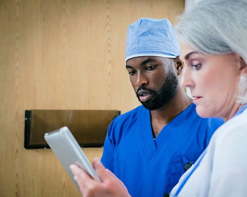 Male doctor and nurse looking at tablet