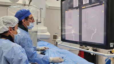 Clinical team performing neurovascular procedure using Philips Azurion system in angiography suite