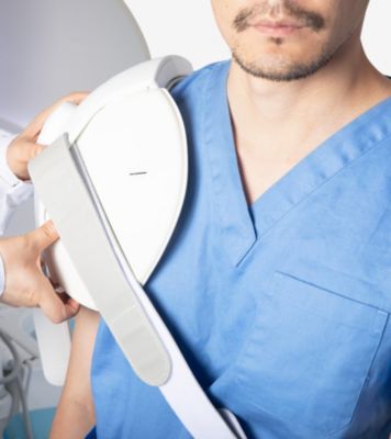 Zorgprofessional plaatst een Philips-beeldvormingsspoel op de schouder voor een musculoskeletale scan