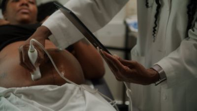 Clinician performing ultrasound scan on a pregnant woman in a March of Dimes mobile clinic