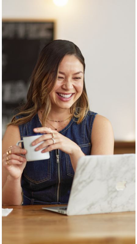 Mujer usando un portátil y sonriendo