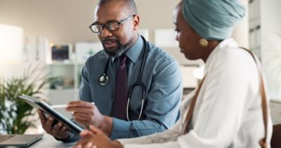 Doctor reviewing medical information with patient on tablet device