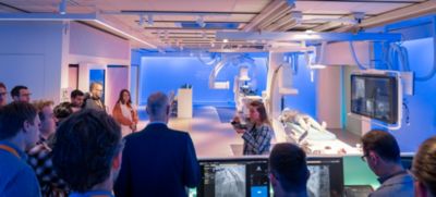 Clinicians observing image guided therapy system during training session

