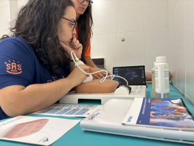 Estudantes de saúde praticando ultrassom usando modelo de simulação e dispositivo portátil em ambiente de treinamento