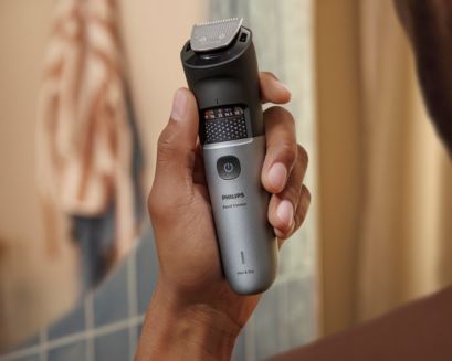 Man som håller en vattensäker skäggtrimmer 7000 i duschen