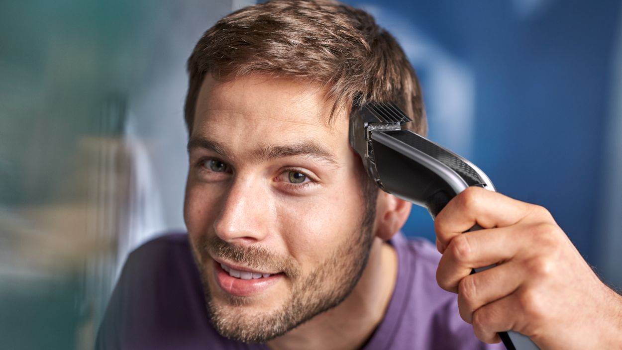 man cutting his own hair evenly