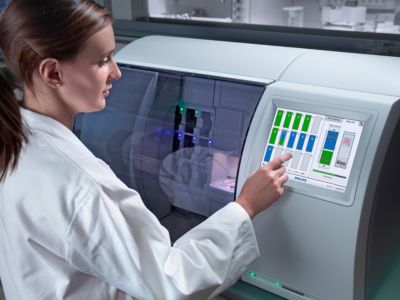 Pathology professional operating digital slide scanner in laboratory
