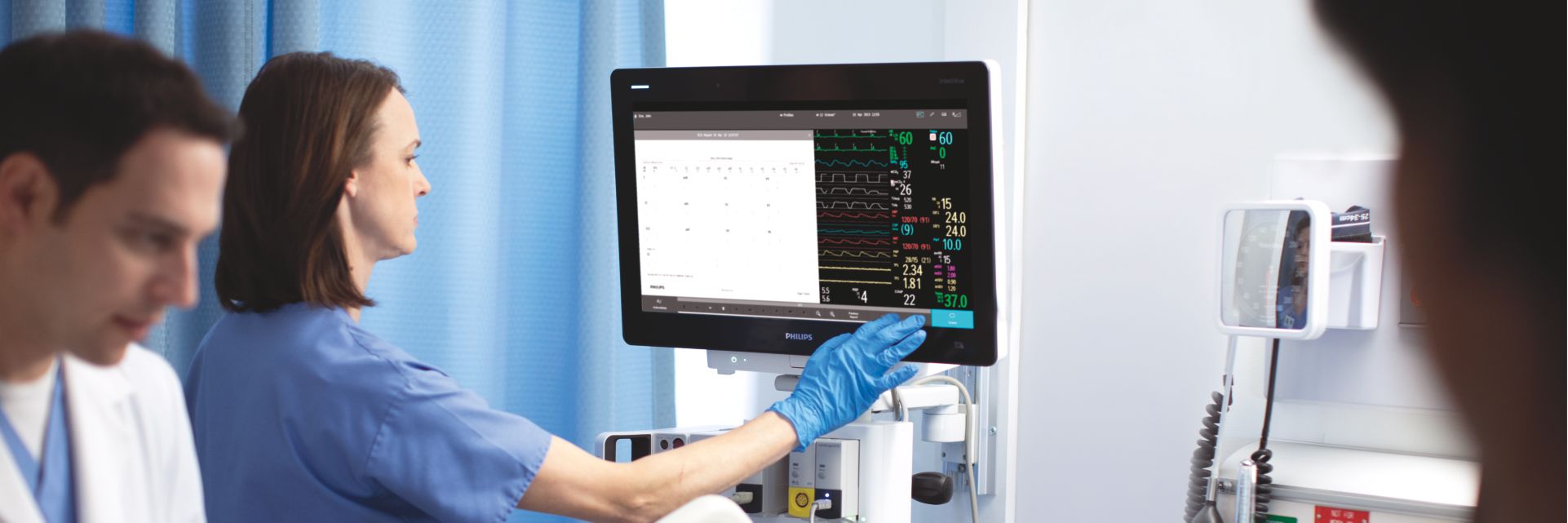 Nurse caring for a patient interacting with Intellivue Monitor