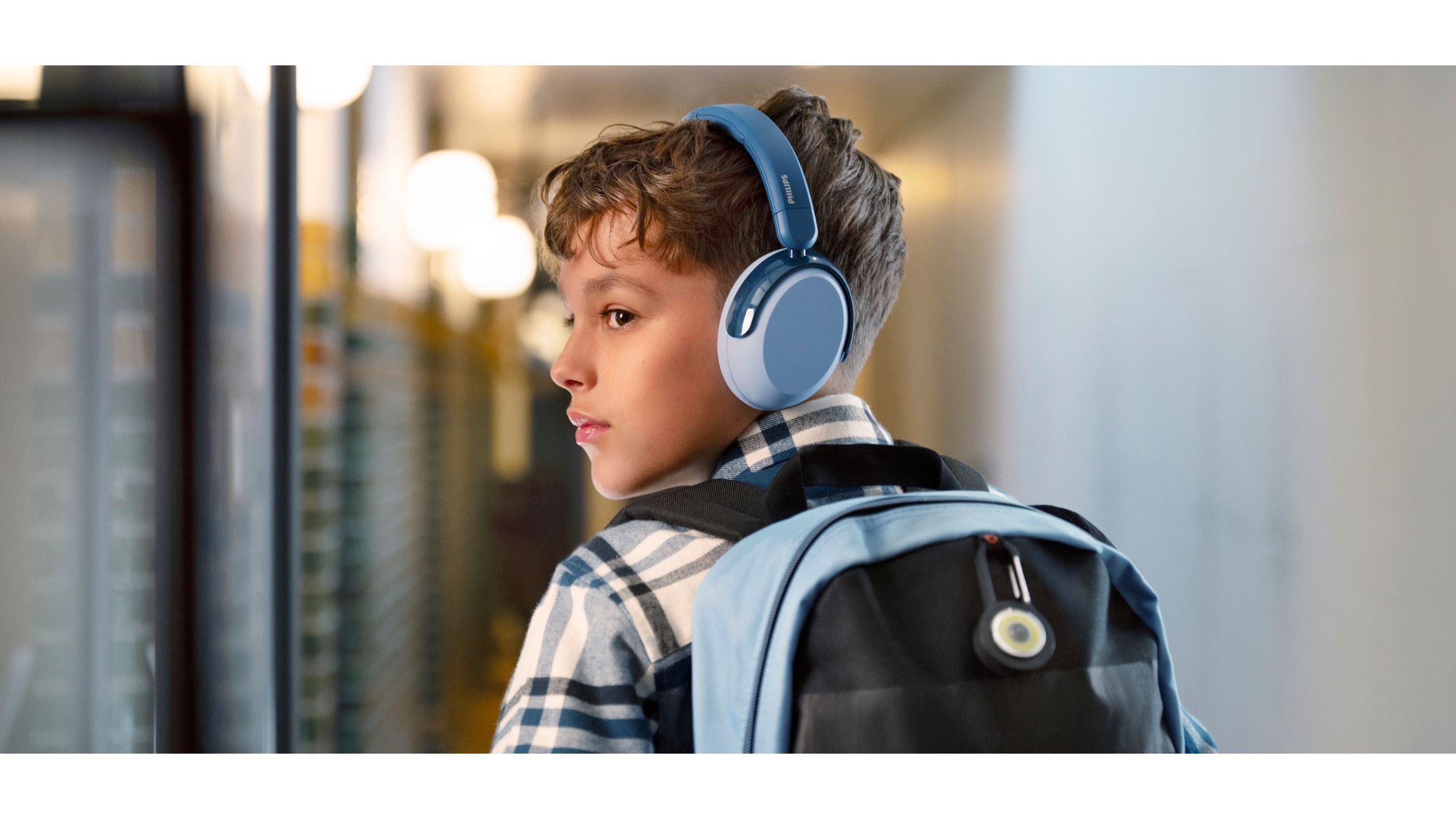 A blue and a pink kids headphones on the floor with toys