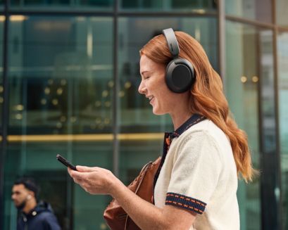 Een vrouw die naar muziek luistert met een Philips-koptelefoon