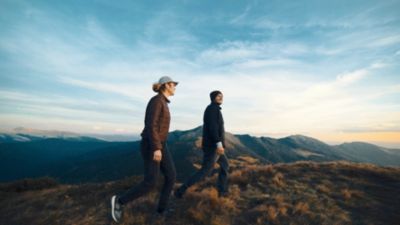 Couple hiking across mountain landscape at sunset