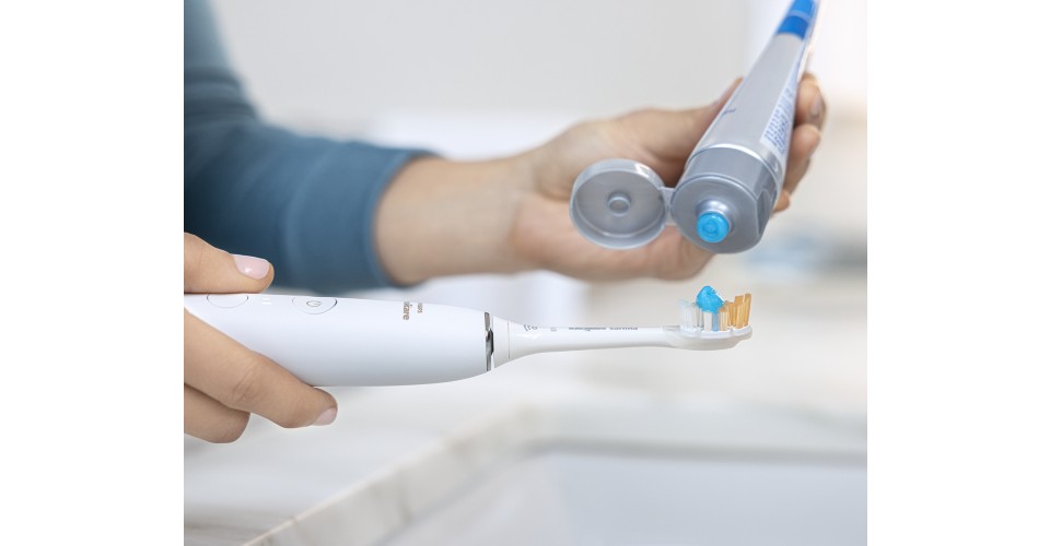 Tandpasta wordt aangebracht op de Sonicare elektrische tandenborstel.