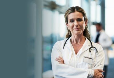 Un professionnel de santé en blouse blanche se tient dans un hôpital moderne