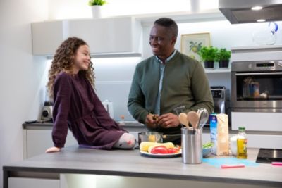 Smiling family in kitchen preparing a meal together.