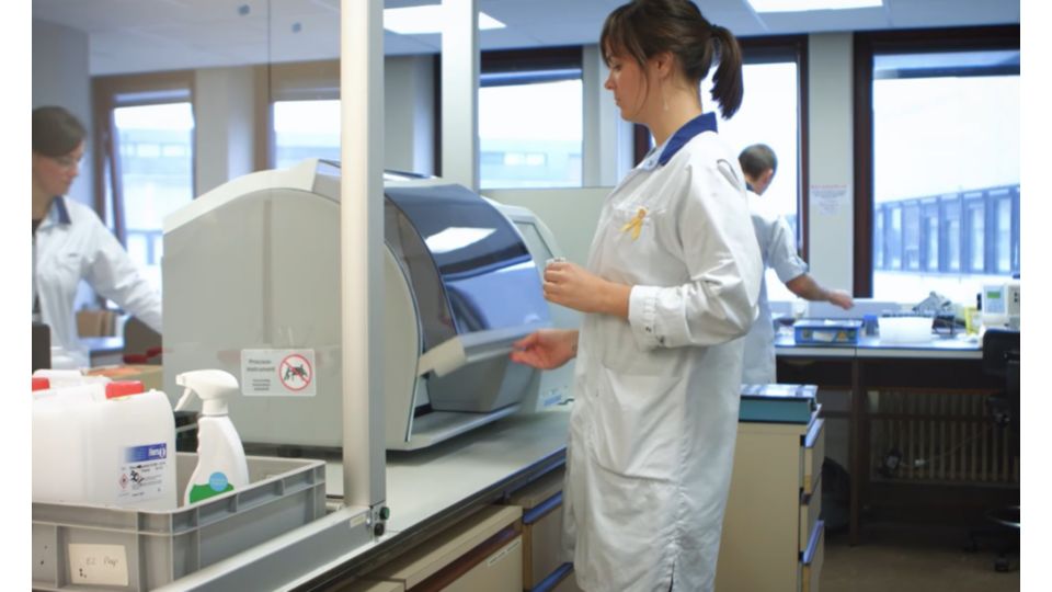 Pathology technician loading slides into the Philips digital pathology scanner