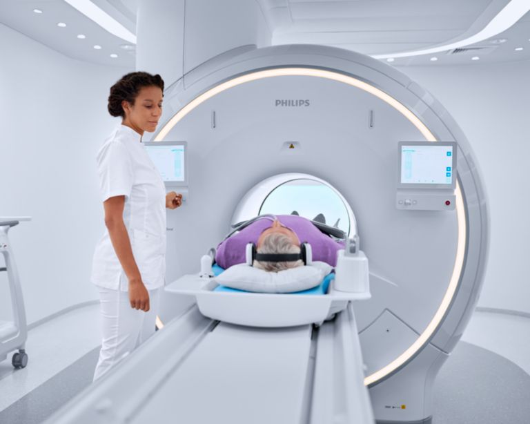 technologist moving patient into the bore of the mri machine 