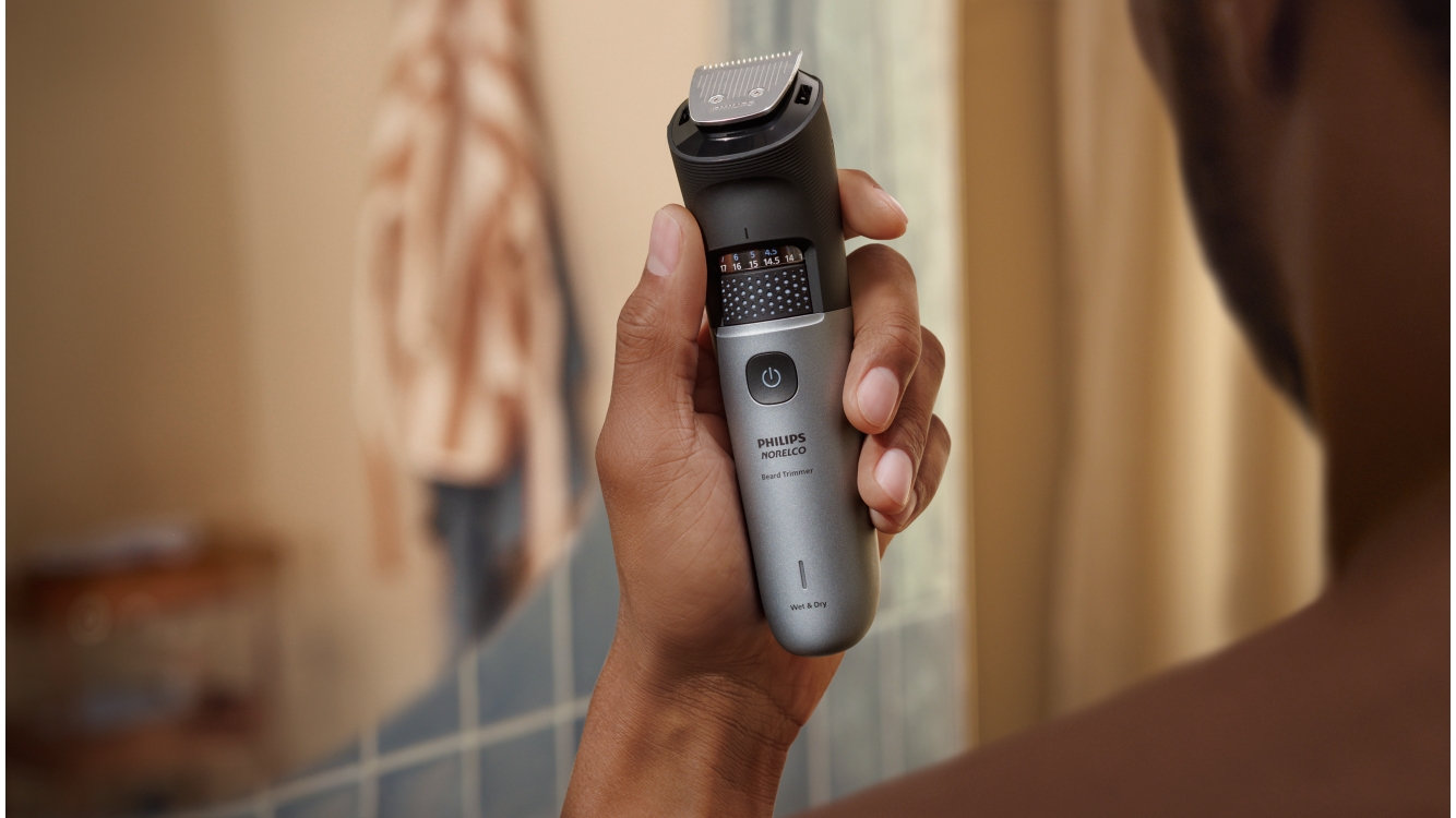Een Philips-baardtrimmer ligt in een open etui op een granieten oppervlak.