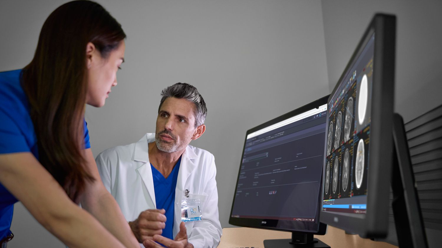 Radiologist and technologist looking at imaging console
