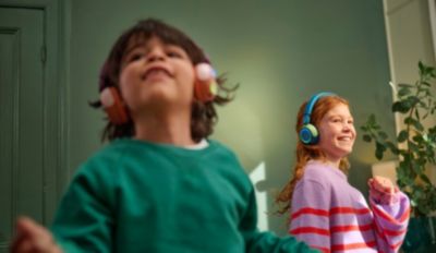 Children wearing wireless headphones while dancing