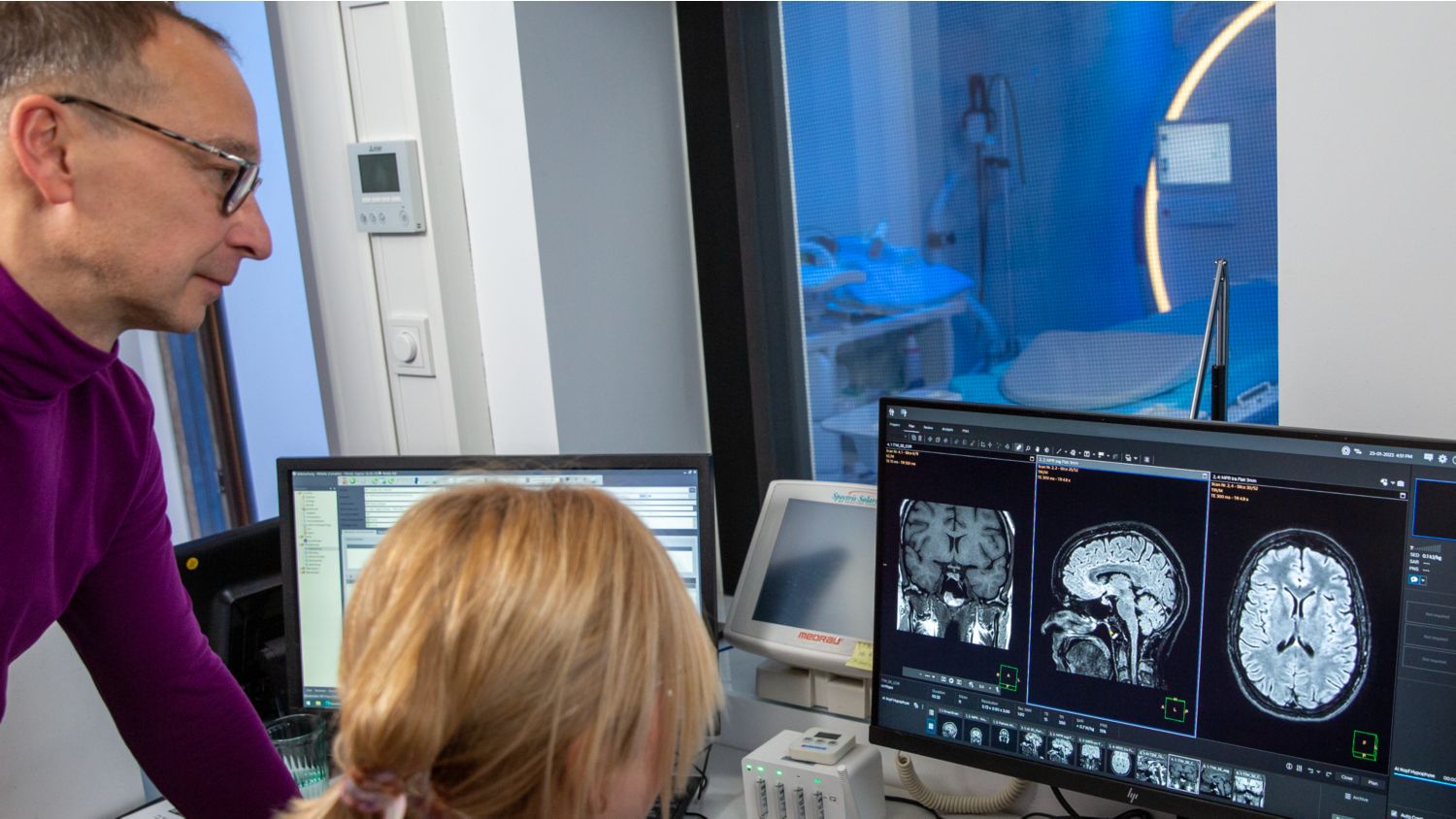 Radiologist and MRI technologist looking at results