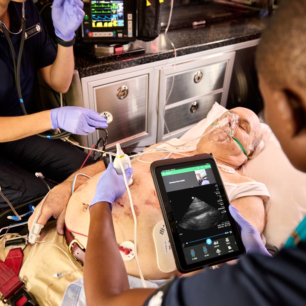Patient in ambulance receiving imaging via handheld ultrasound utilizing tele-ultrasound.  
