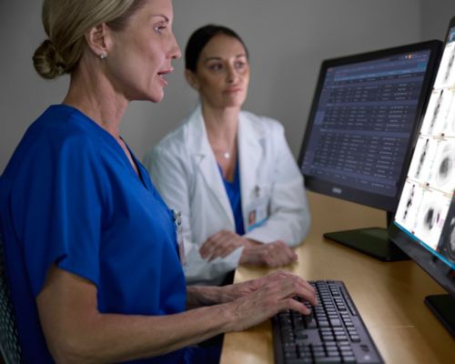 Radiologist conferring in front of dual screens