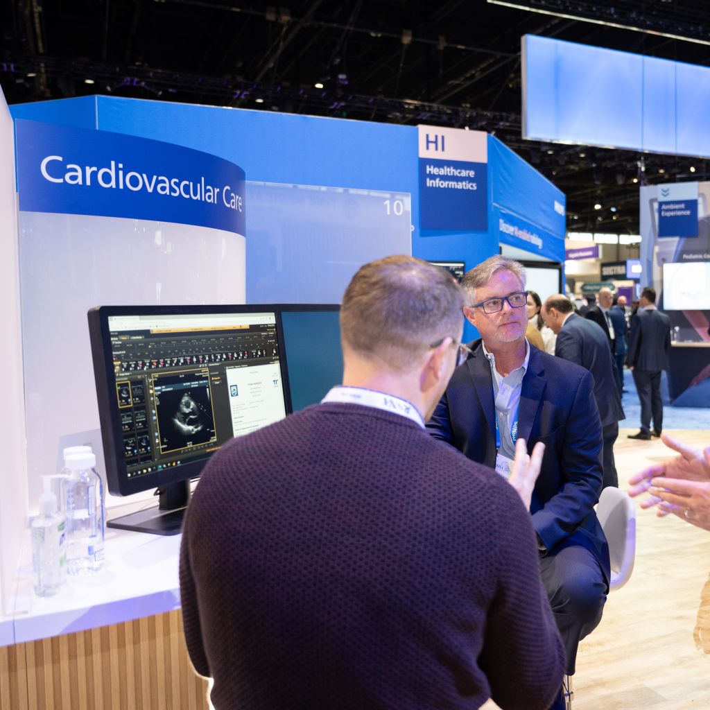 People talking at a computer screen while attending a trade show