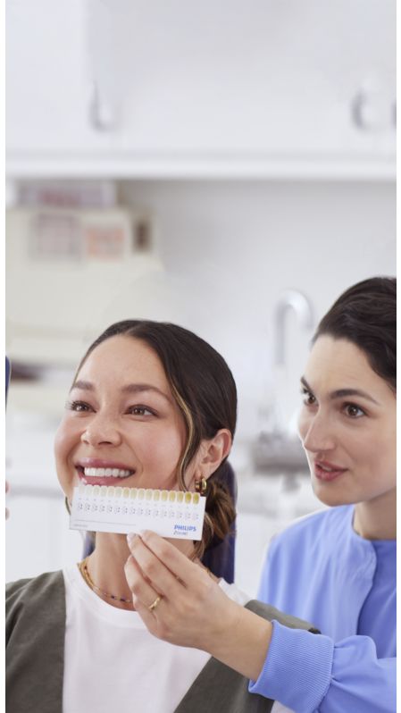 A dental professional using a Philips Zoom! shade guide