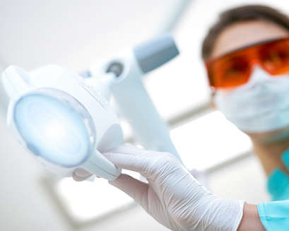 A dental professional holding a Philips Zoom! WhiteSpeed lamp