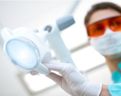 A dental professional holding a Philips Zoom! WhiteSpeed lamp