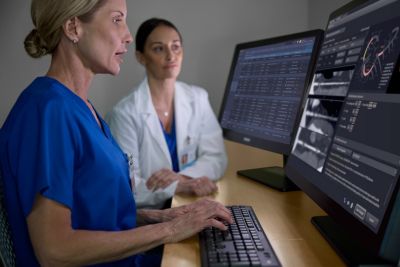 doctor and technician looking at two monitors