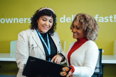 Two employees reviewing laptop together in office