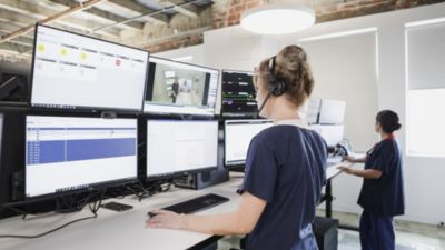 Two healthcare workers monitoring patient data on multiple screens