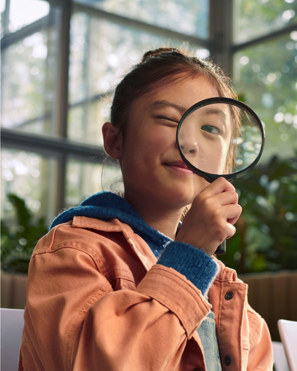 girl looking through magnifying glass