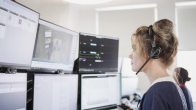A healthcare worker monitoring patient data on multiple screens close-up