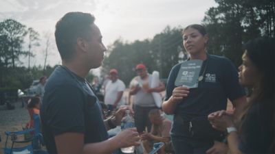 Healthcare workers speaking with farmworkers outdoors