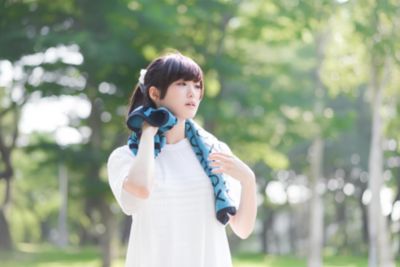 運動後に屋外で汗を拭く女性