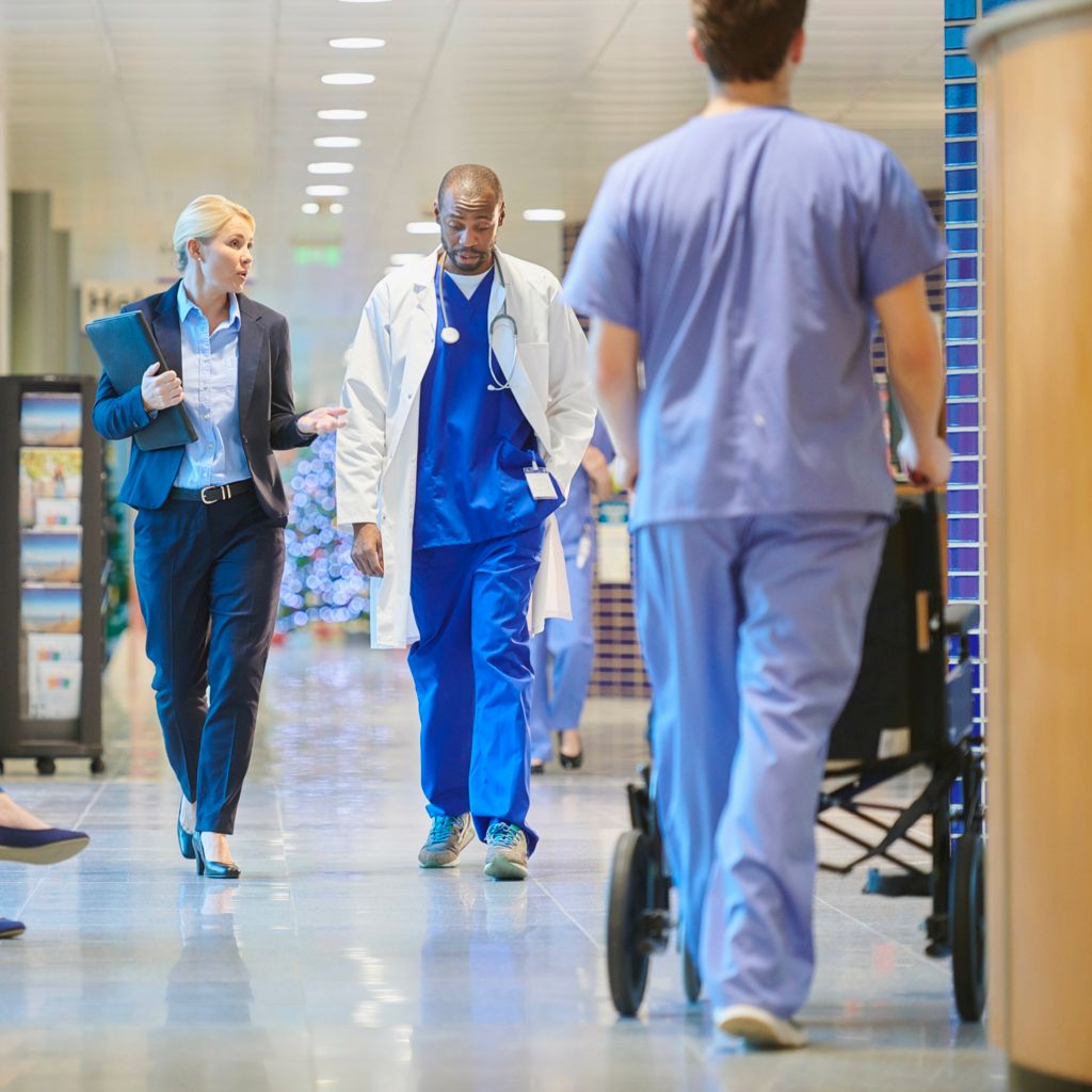 medical professionals walking down a hallway in a hospital, talking to each other